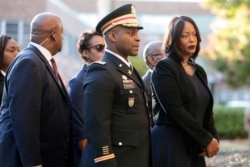 Mourners, including Maya Rockeymoore, right, widow of U.S. Rep. Elijah Cummings, follow behind pallbearers walking with the congressman's body while arriving at Morgan State University ahead of a public viewing in Baltimore, Oct. 23, 2019.