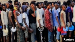 Men who fled fighting in Ethiopia's Tigray region queue for food rations at Um-Rakoba camp, on the Sudan-Ethiopia border, in Al-Qadarif state, Sudan, Nov. 19, 2020.