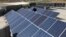 FILE - A Palestinian worker installs solar panels atop the roof of a medical center in Gaza City, March 1, 2016.