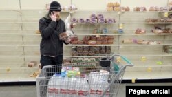 Anchorage resident C.J. Johnson stocks up on water and bread at a local grocery after a 7.0-magnitude earthquake, Nov. 30, 2018. The earthquake damaged roadways and knocked many traffic lights out of service, snarling traffic.