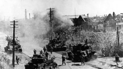 North Korean combatants plunge together with the tank unit in Seoul during the Korean War, undated. (KCNA/AP)