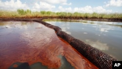 FILE - Oil from the Deepwater Horizon oil spill is seen floating on the surface of the water in Bay Jimmy in Plaquemines Parish, Louisiana, June 26, 2010.