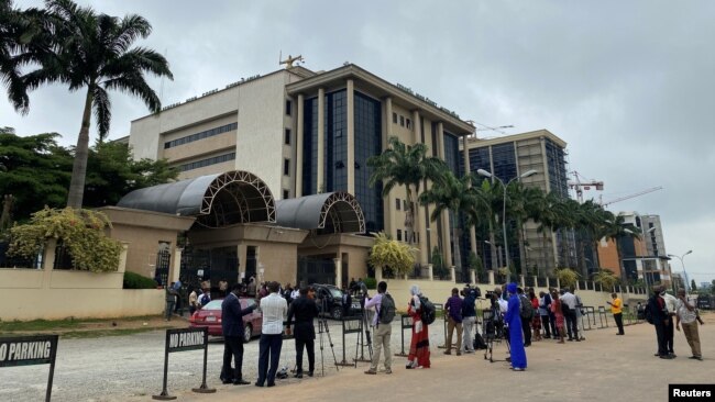 FILE - Journalists are stationed opposite the Federal High Court as they await the arrival of IPOB leader Nnamdi Kanu at the court in Abuja, Nigeria, July 26, 2021.