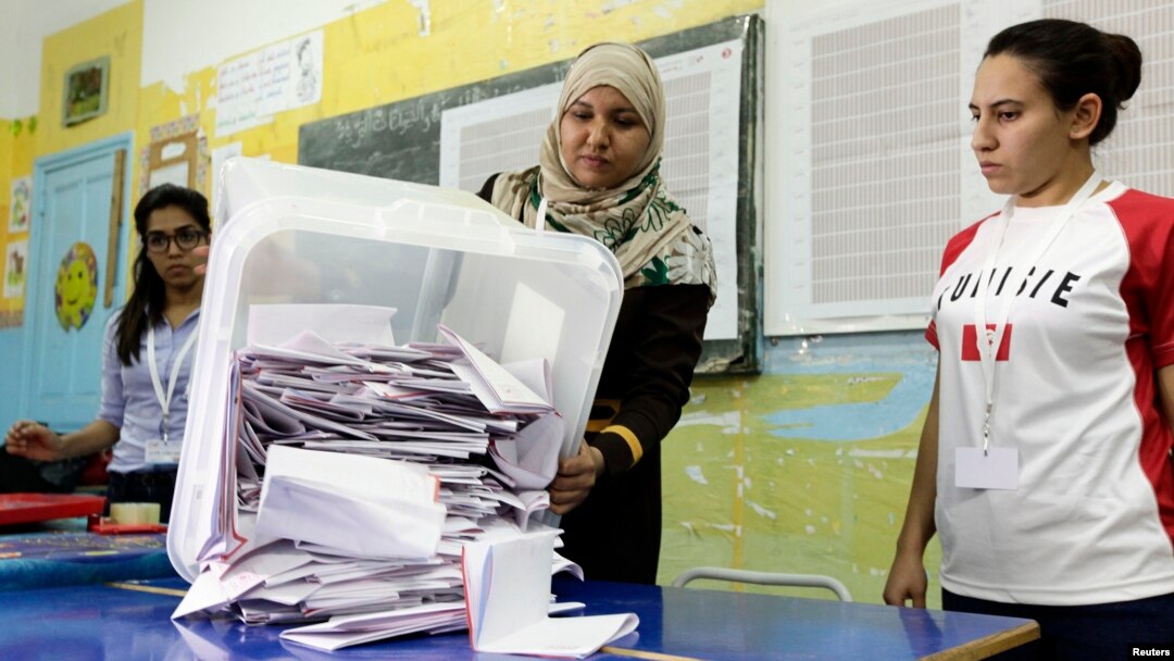 Petugas di Tunis menumpahkan kertas suara menyusul pemilu di Tunisia (26/10). (Reuters/Anis Mili)
