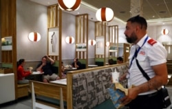 FILE - People are seen in a McDonald's in London, July 22, 2020.