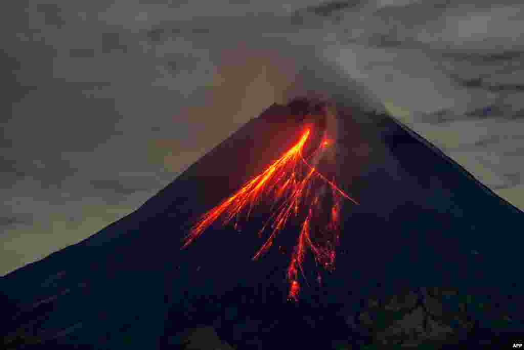 Mount Merapi spews lava onto its slopes during an eruption as seen from Srumbung village in Magelang, Central Java, Indonesia.