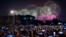 FILE - People use smartphones to film fireworks exploding at Tiananmen Square in Beijing on Oct. 1, 2019, as part of a gala evening commemorating the 70th anniversary of the founding of Communist China.