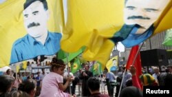 Protesters wave flags with the picture of Kurdistan Workers Party (PKK)'s jailed leader Abdullah Ocalan during a demonstration against the Turkish army operations on Kurdish militants, in central Brussels, Belgium, Aug. 8, 2015. 