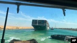 En esta foto publicada por la Autoridad del Canal de Suez, el Ever Given, un carguero con bandera de Panamá es acompañado por remolcadores del Canal de Suez mientras se mueve en el Canal de Suez, Egipto, 29 de marzo de 2021.