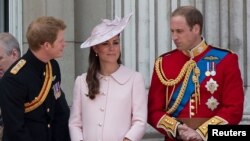 El príncipe Harry dialoga con la duquesa de Cambridge, Catherine Middleton y su hermano el príncipe William durante una ceremonia el mes pasado en el Palacio de Buckingham.