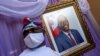 A man stands next to a portrait of slain Haitian President Jovenel Moise placed on a memorial at the city hall in Cap-Haitien, Aug. 22, 2021.