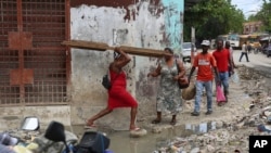 Seorang warga tampak melewati genangan air di salah satu sudut di pusat Kota Port-au-Prince, Haiti, pada 23 September 2024. (Foto: AP/Odelyn Joseph)