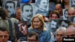 FILE - Human rights activists hold portraits of victims during a demonstration to commemorate the 1915 mass killing of Armenians in the Ottoman Empire, in central Istanbul, Turkey, Apr. 24, 2018. 
