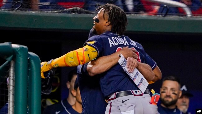 Un compañero del venezolano Ronald Acuña Jr. lo abraza para celebrar su jonrón 40 del año, este viernes 22 de septiembre de 2023, en el Nationals Park de Washington.