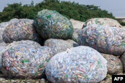 FILE - Used plastic containers stand at a dumpsite in UNILAG ready to be recycled in Lagos on January 23, 2024.