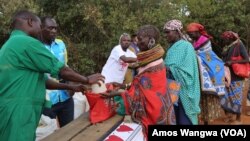 Des femmes récupèrent des donations de Laikipia Nature Conservancy au Kenya, où Kuki Gallmann distribute de l'eau et de la nourriture, le 19 mars 2017. (Amos Wangwa/VOA)