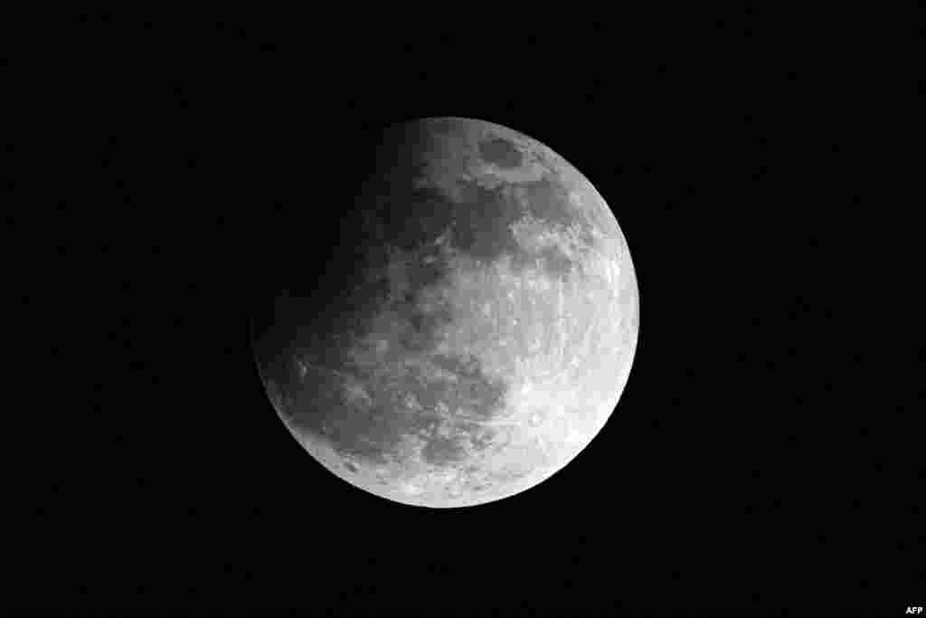 Una luna llena, también llamada &quot;Luna de la cosecha&quot; y una de las cuatro superlunas del año, se eleva sobre Caracas durante un eclipse lunar parcial, a última hora del 17 de septiembre de 2024. &nbsp;