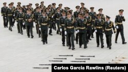 Anggota band militer China tampak bersiap sebelum tampil pada upacara memperingati Hari Martir di Lapangan Tiananmen, di Beijing, dimulai pada 30 September 2021. (Foto: Reuters/Carlos Garcia Rawlins)