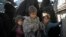 Women and children exit the back of a truck as they arrive at a U.S.-backed Syrian Democratic Forces (SDF) screening area after being evacuated out of the last territory held by Islamic State militants, in the desert outside Baghuz, Syria, March 1, 2019. 