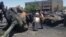 An image from Edlib News Network shows citizens looking at a Syrian tank destroyed during clashes between rebels and Syrian government forces in Idlib province, June 4, 2012. (The photo cannot be independently confirmed)