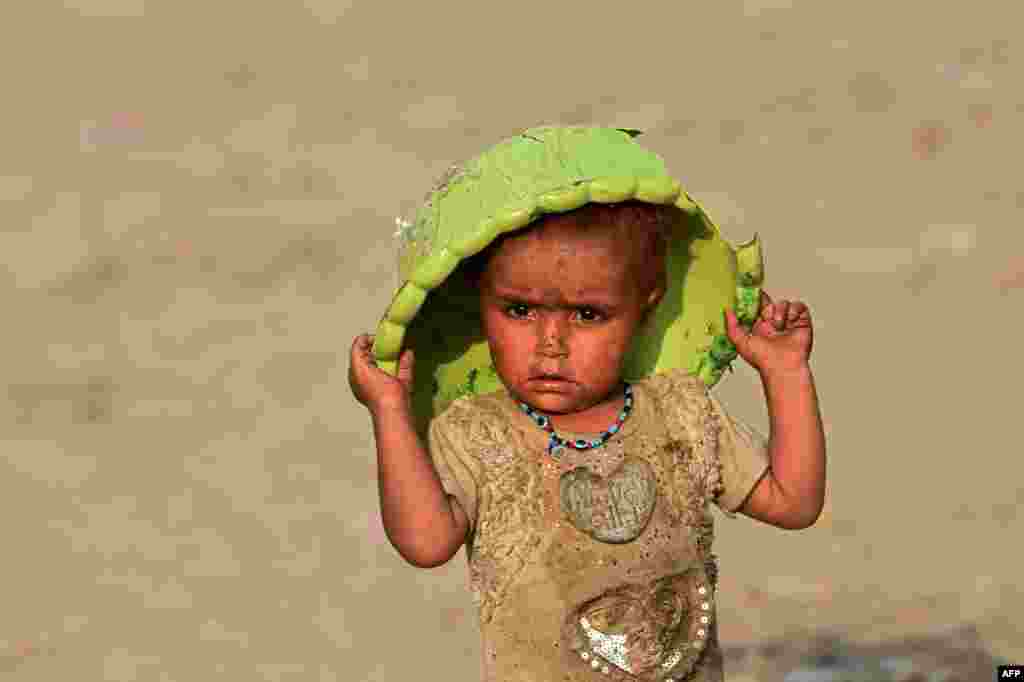 An Afghan refugee child plays on the outskirts of Lahore, Pakistan, June 19, 2021.