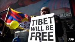 FILE - A protester displays a placard during a demonstration against China in Times Square in New York, Feb. 13, 2015, demanding for the freedom of Tibet. New research has renewed global discussion about China's decadeslong persecution of Tibetans in the autonomous region.