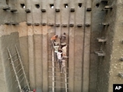 FILE—Malians take part in the annual replastering of the world's largest mud-brick building, the Great Mosque of Djenne, Mali, May 12, 2024.