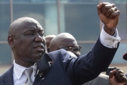 Attorney Ben Crump raises his arm while addressing media during the public viewing for George Floyd at The Fountain of Praise church in Houston, June 8, 2020.