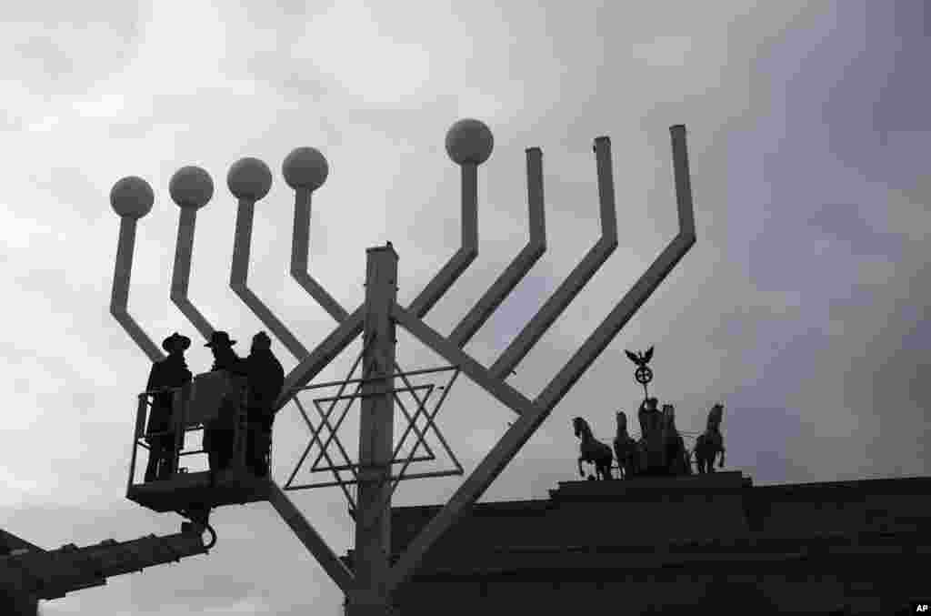 Rabbis inspect a giant Hanukkah Menorah set up by the Jewish Chabad Educational Center ahead of the Jewish Hanukkah holiday, at the Pariser Platz in Berlin.