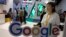 Visitors talk to staff members at a Google stand during the Global Mobile Internet Conference (GMIC) in Beijing, April 28, 2017. Google's search engine and email service remains blocked in mainland China but Chinese companies make use of its ad services to reach a global audience.