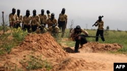 FILE - Rebel fighters are seen training in the northeastern city of Deir Ezzor, March 25, 2014.