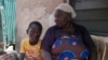 FILE - Funmilayo Kotun, a 66-year-old malaria patient, sits with her grandson Ayomide Kotun outside her house in the Makoko neighborhood of Lagos, Nigeria, on April 20, 2024.