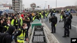 Demonstrators wearing yellow vests walk on the highway in Lyon, France, Jan. 5, 2019. Protesters reiterated their call for Emmanuel Macron, denounced as the president of the rich, to resign.