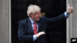 Britain's Prime Minister Boris Johnson joins in the applause on the doorstep of 10 Downing Street in London during the weekly "Clap for our Carers" Thursday, May 7, 2020. The COVID-19 coronavirus pandemic has prompted a public display of appreciation for…