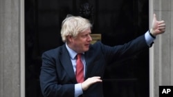 Britain's Prime Minister Boris Johnson joins in the applause on the doorstep of 10 Downing Street in London during the weekly "Clap for our Carers" Thursday, May 7, 2020. The COVID-19 coronavirus pandemic has prompted a public display of appreciation for…