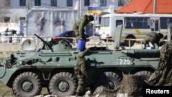 Soldados rusos frente a una base naval ucraniana en la ciudad portuaria de Feodosia.