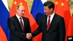 Presiden Rusia Vladimir Putin (kiri) dan Presiden China Xi Jinping dalam pertemuan di Beijing tahun lalu (foto: dok).