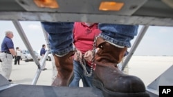 FILE - Shackled Mexican immigrants are boarded onto a U.S. Immigration and Customs Enforcement jet chartered for deportation of illegal immigrants at O'Hare in Chicago, Il., May 25, 2010. 