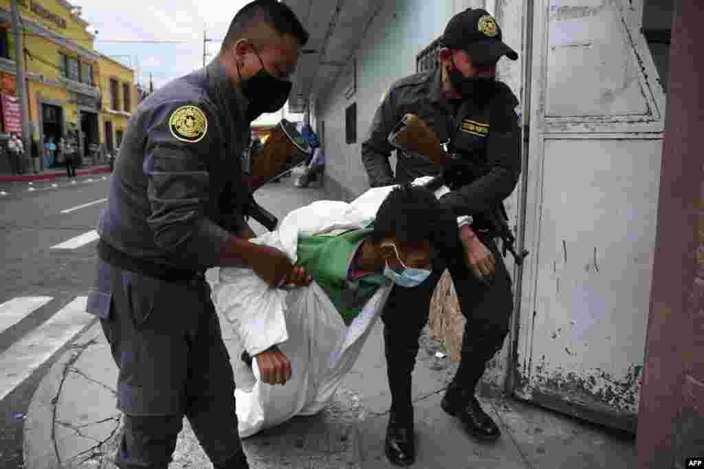 Penitentiary system guards carry an inmate with symptoms related to the novel coronavirus at the COVID-19 unit of San Juan de Dios hospital in Guatemala City, July 13, 2020.