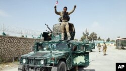 FILE - An Afghan soldier raises his hands as a victory sign after Kunduz was retaken from Taliban forces, Oct. 2, 2015. 