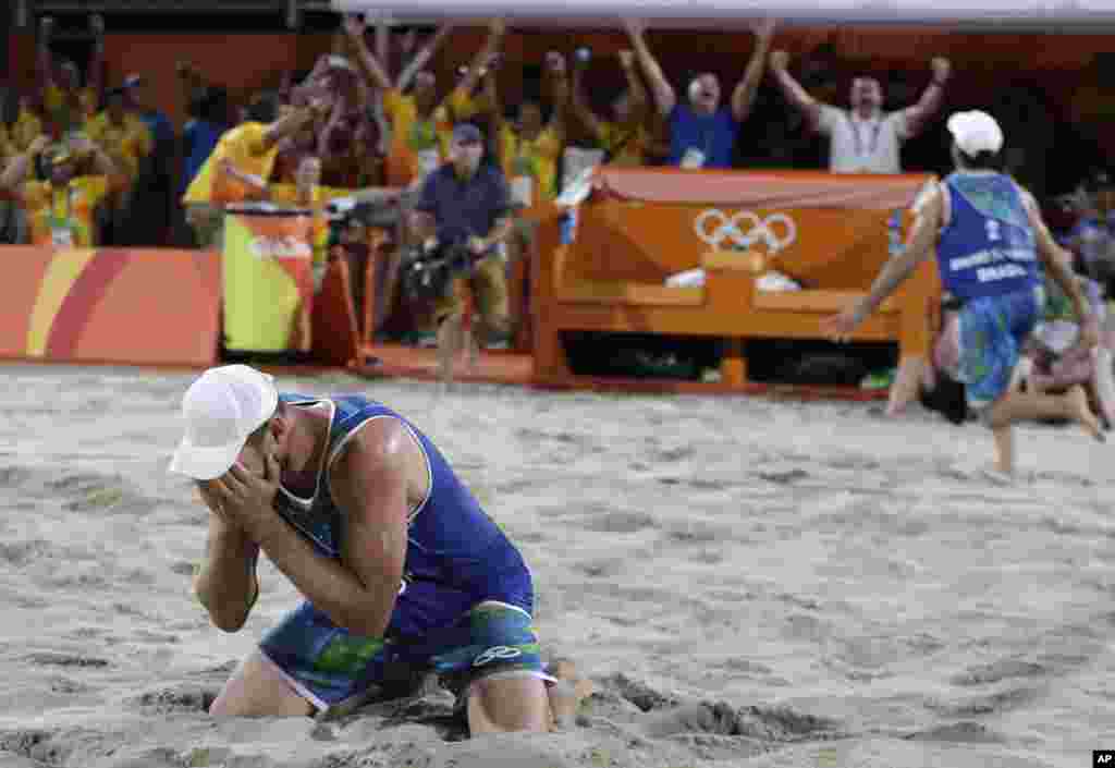 Pemain tim Brazil Alison Cerutti (kiri) dan Bruno Oscar Schmidt (kanan) merayakan kemenangan dalam semifinal bola voli pantai atas Belanda (16/8).&nbsp;(AP/Petr David Josek)