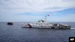 Kapal pemasok muatan Filipinan (kiri) berupaya menghindari kapal penjaga pantai China ketika berlayar di dekat area beting Ayungin, di Laut China Selatan, pada 22 Agustus 2023. (Foto: AP/Aaron Favila)