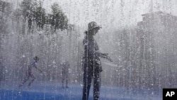 FILE: A woman cools down in a fountain in London, where temperatures could approach 40c. A blanket of hot air stretching from the Mediterranean to the North Sea is giving much of western Europe a powerful heat wave that has ignited fires in Spain and France. 