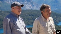 U.S. Secretary of State Rex Tillerson, left, and Eugenio Breard, center, director of Argentina's national parks, stand on a deck overlooking the Nahuel Huapi lake in Bariloche, Argentina, Feb. 3, 2018. Tillerson spent a day in Argentina's Patagonia region during a weeklong trip to Latin America.