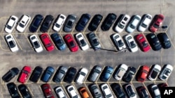 Cars are parked in an auto dealer in Green Park, Mo. U.S. retail sales recorded a record drop in auto sales as the coronavirus outbreak closed down thousands of stores and shoppers stayed home.