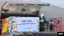 A South Korean worker unloads cargo containing Pfizer's antiviral COVID-19 pill, Paxlovid, at a cargo terminal of the Incheon International Airport in Incheon on Jan. 13, 2022