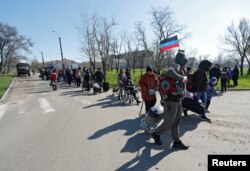 Evacuees walk to board buses before leaving the city during Ukraine-Russia conflict in the southern port of Mariupol, Ukraine, April 20, 2022.