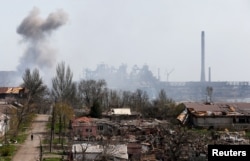 Smoke rises above a plant of Azovstal Iron and Steel Works company and buildings damaged in the course of Ukraine-Russia conflict in the southern port city of Mariupol, Ukraine, April 18, 2022.