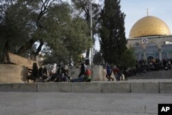 Pengunjuk rasa Palestina berlindung saat bentrok dengan polisi Israel di kompleks Masjid al-Aqsa di Kota Tua Yerusalem, Jumat, 22 April 2022. (Foto: AP)