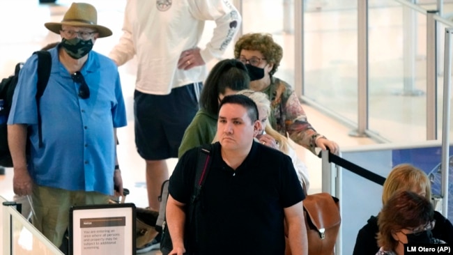 Travelers wait in a security line at Love Field in Dallas, Tuesday, April 19, 2022